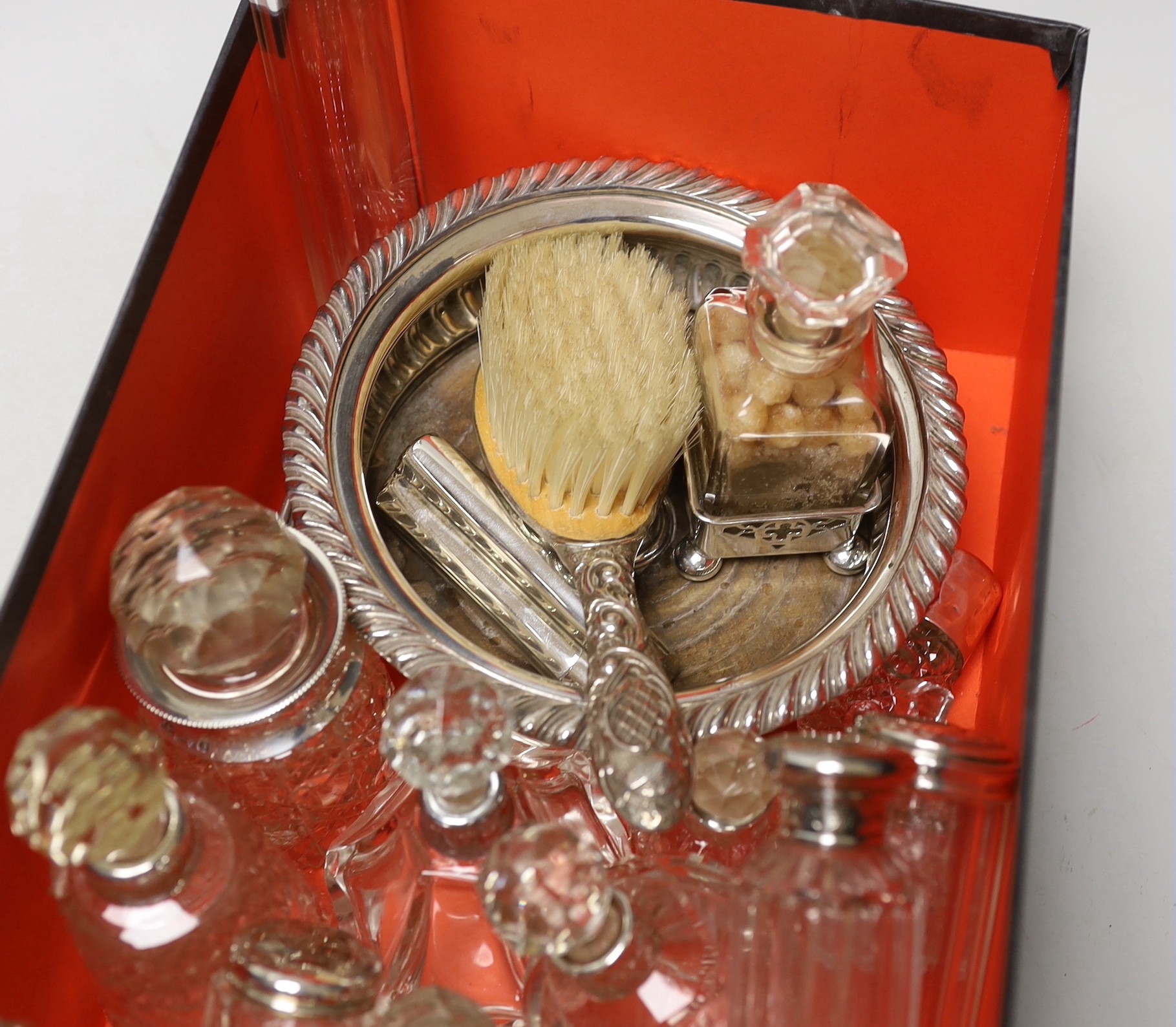 A collection of assorted silver mounted glass scent bottles and other items including a wine coaster etc.